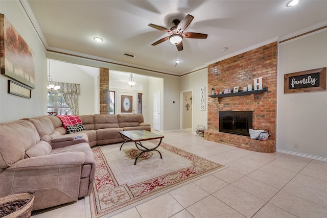 living room featuring ceiling fan with notable chandelier, a fireplace, light tile patterned floors, and crown molding