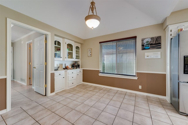 unfurnished dining area with light tile patterned floors and ornamental molding