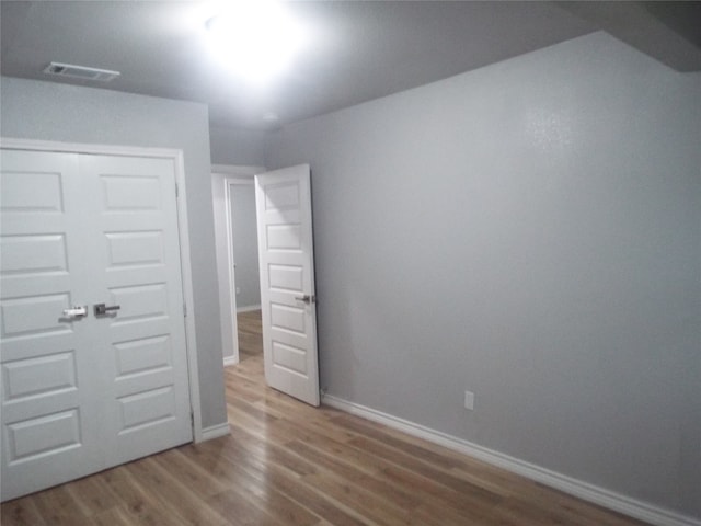 unfurnished bedroom with hardwood / wood-style flooring and a closet