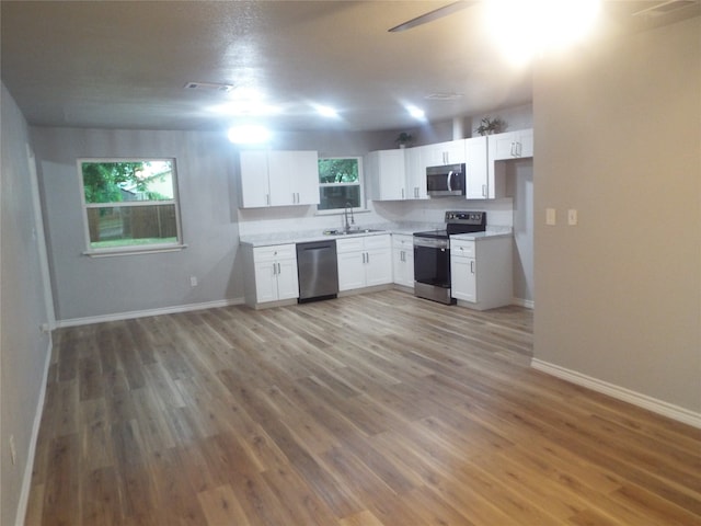 kitchen featuring white cabinetry, hardwood / wood-style floors, sink, and stainless steel appliances