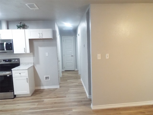 kitchen featuring white cabinetry, light hardwood / wood-style flooring, and stainless steel appliances