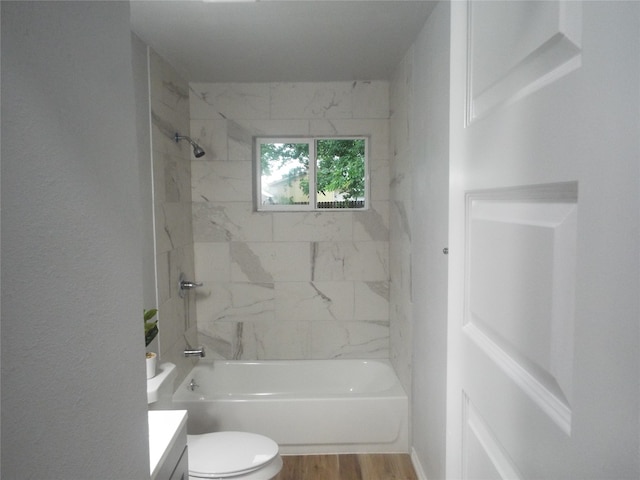 full bathroom featuring tiled shower / bath, vanity, hardwood / wood-style floors, and toilet