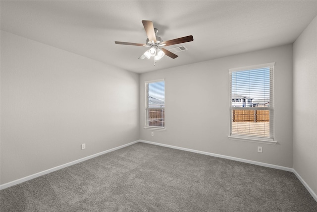 empty room with ceiling fan, a healthy amount of sunlight, and carpet