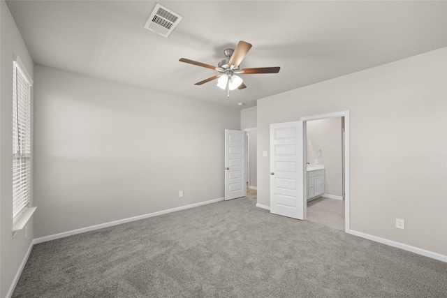 unfurnished bedroom with ceiling fan, connected bathroom, and light carpet