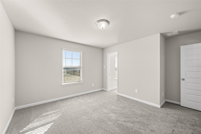 spare room featuring carpet floors and a textured ceiling