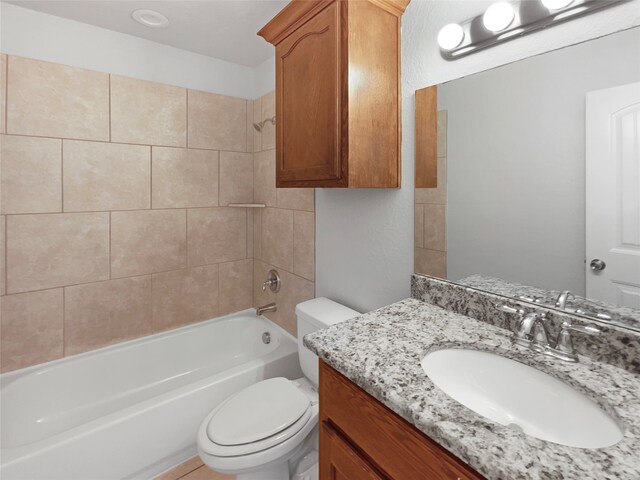 full bathroom featuring tiled shower / bath combo, vanity, and toilet