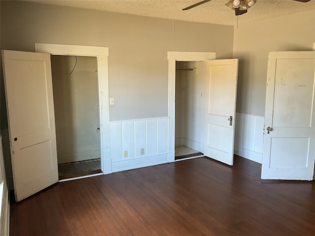 unfurnished bedroom featuring ceiling fan, a textured ceiling, and dark wood-type flooring