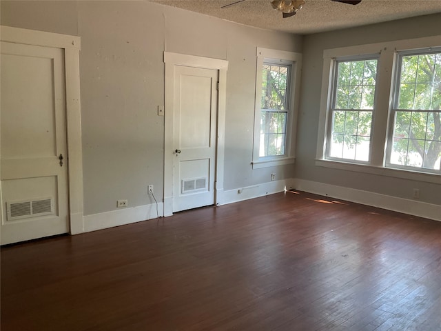 unfurnished bedroom with ceiling fan, dark wood-type flooring, and a textured ceiling