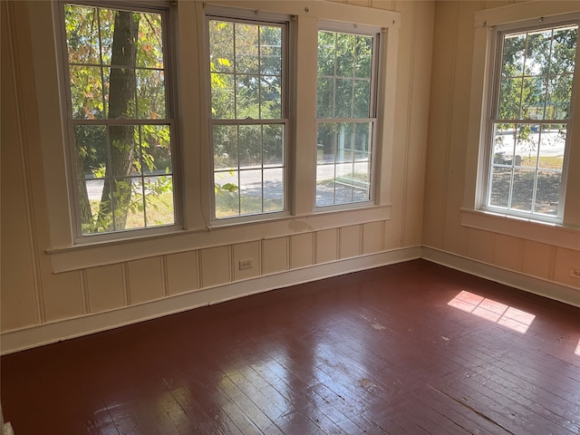 unfurnished room featuring dark hardwood / wood-style flooring and plenty of natural light