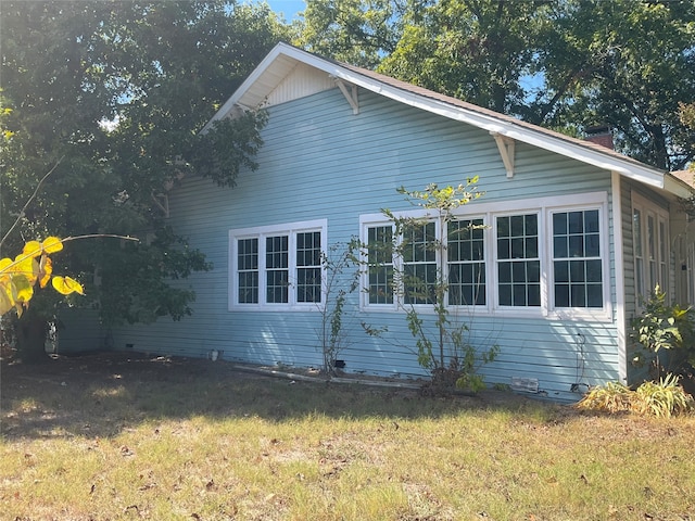 view of property exterior with a lawn