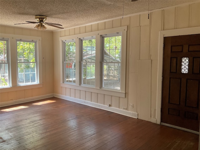 entrance foyer featuring ceiling fan, a textured ceiling, plenty of natural light, and dark hardwood / wood-style floors