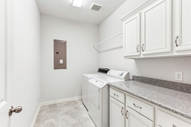 washroom featuring separate washer and dryer, electric panel, and cabinets