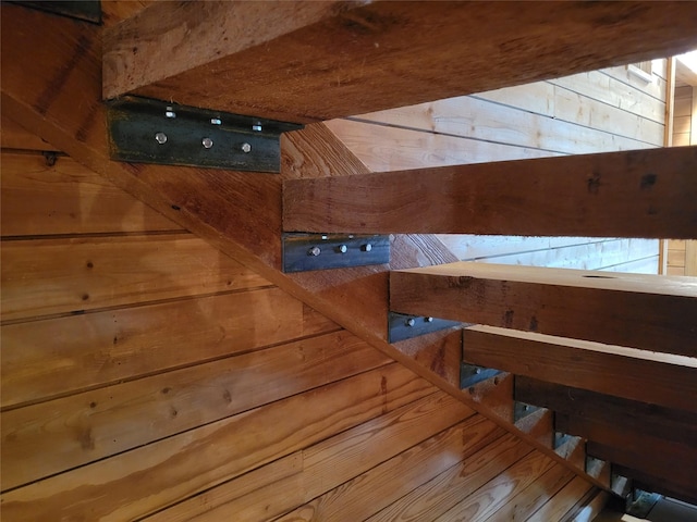staircase featuring wood walls