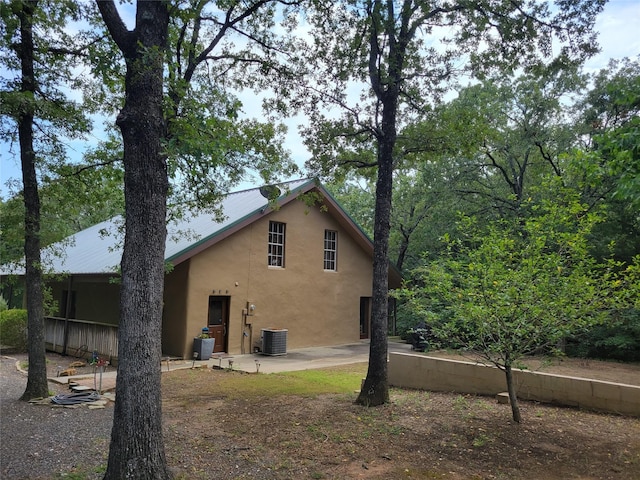 rear view of property featuring stucco siding, cooling unit, and a patio area