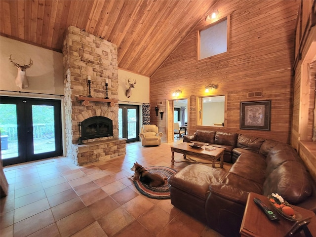 tiled living room with wooden walls, high vaulted ceiling, wooden ceiling, and french doors