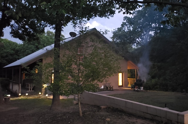 property exterior at dusk featuring a patio