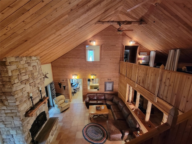 living room featuring wood ceiling, wood walls, a fireplace, high vaulted ceiling, and ceiling fan