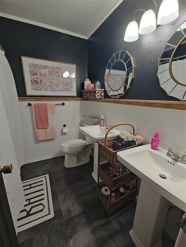 bathroom with a textured ceiling, tile walls, crown molding, and toilet