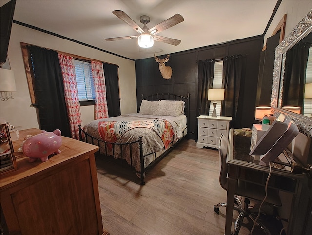 bedroom with light wood-type flooring, ceiling fan, and crown molding