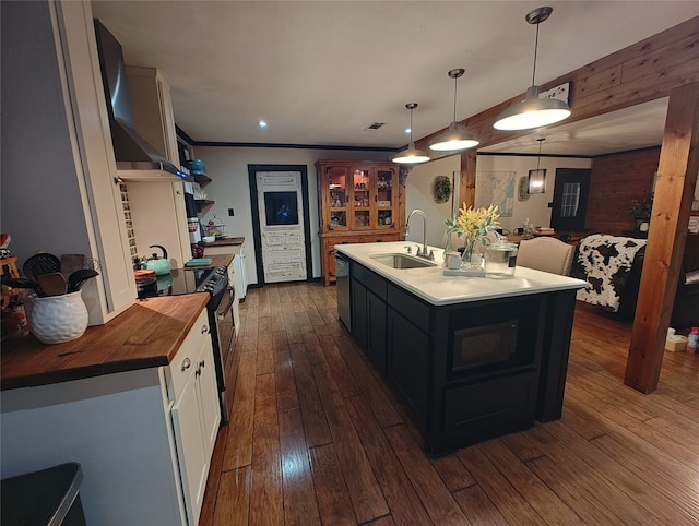 kitchen featuring white cabinets, pendant lighting, sink, a kitchen island with sink, and dark hardwood / wood-style floors