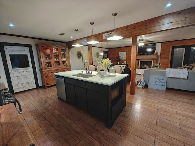 kitchen featuring pendant lighting, a kitchen island with sink, sink, dark hardwood / wood-style flooring, and stainless steel dishwasher