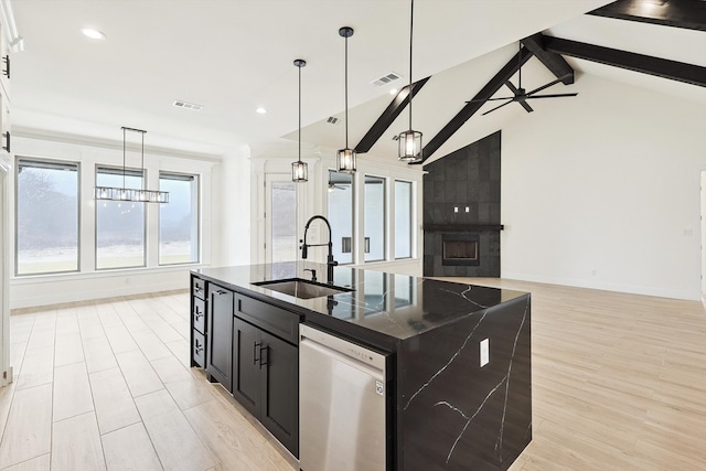 kitchen with dishwasher, light hardwood / wood-style flooring, vaulted ceiling with beams, a kitchen island with sink, and sink