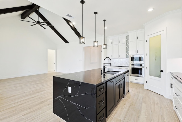 kitchen featuring lofted ceiling with beams, sink, an island with sink, stainless steel appliances, and ceiling fan