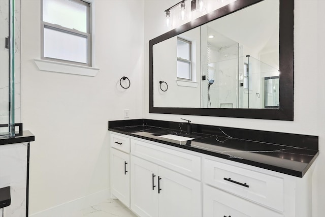 bathroom featuring a healthy amount of sunlight, a shower with door, and vanity