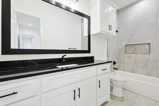 full bathroom featuring vanity, tiled shower / bath combo, and toilet