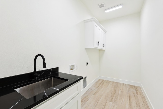 laundry area with cabinets, hookup for an electric dryer, light hardwood / wood-style floors, sink, and hookup for a washing machine