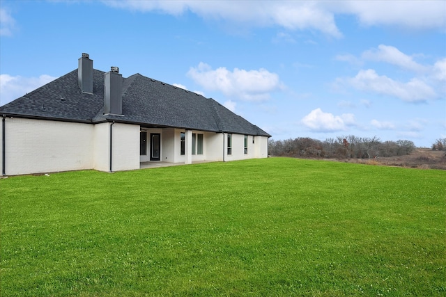 back of property featuring a lawn and a patio area