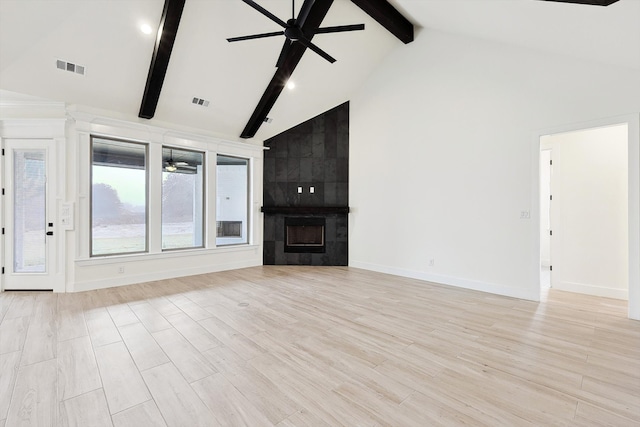 unfurnished living room featuring ceiling fan, beam ceiling, light hardwood / wood-style floors, and a tile fireplace