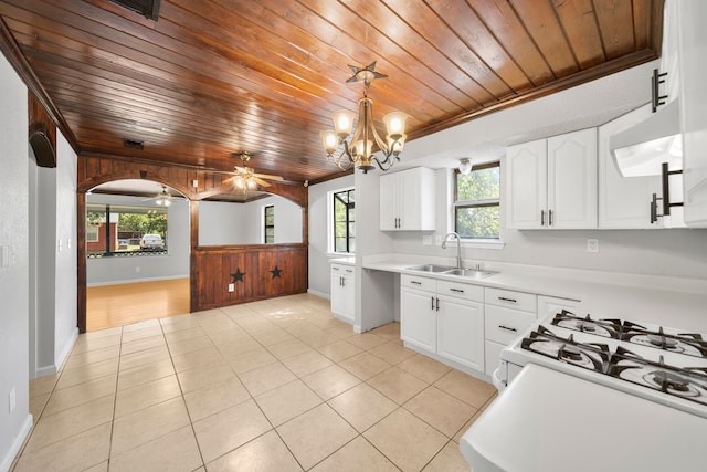 kitchen with hanging light fixtures, white cabinets, ceiling fan with notable chandelier, wooden ceiling, and sink