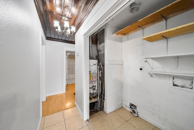 interior space featuring wood ceiling, gas water heater, light tile patterned floors, electric dryer hookup, and a chandelier