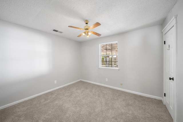 spare room featuring ceiling fan, carpet floors, and a textured ceiling