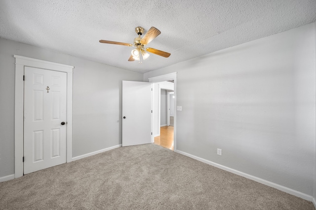 unfurnished bedroom featuring ceiling fan, a textured ceiling, and carpet flooring