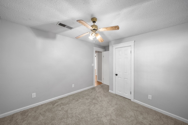 carpeted spare room with a textured ceiling and ceiling fan