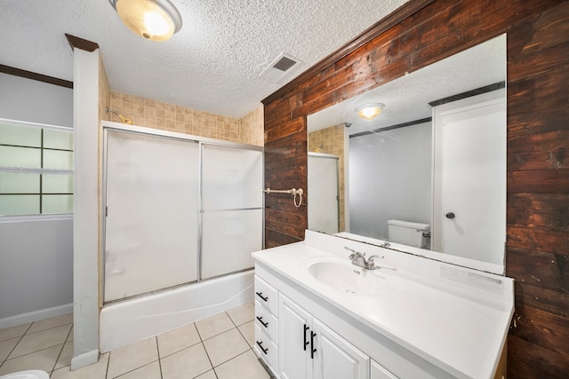 full bathroom featuring a textured ceiling, vanity, toilet, and tile patterned floors