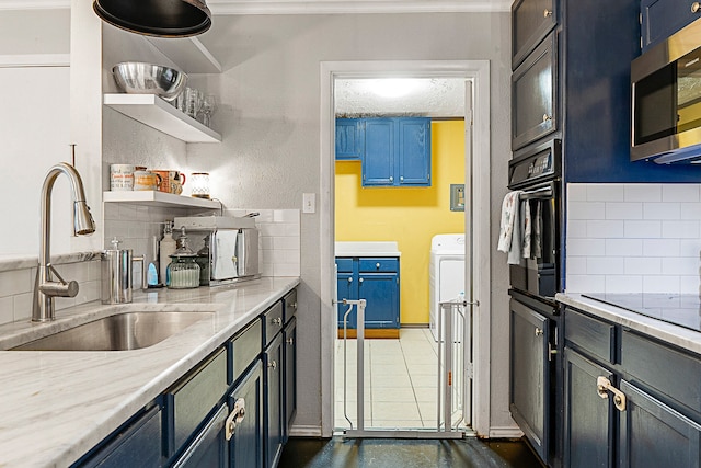 kitchen with black appliances, decorative backsplash, light stone countertops, and blue cabinetry