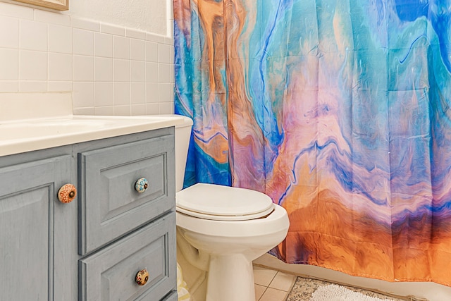 bathroom featuring tile walls, vanity, walk in shower, toilet, and tile patterned floors