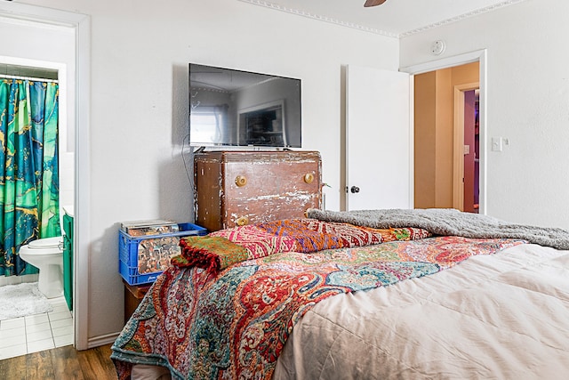 bedroom featuring connected bathroom, ceiling fan, and dark hardwood / wood-style floors