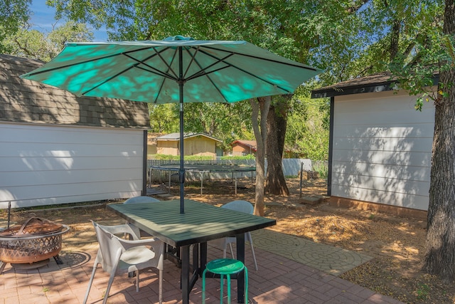 view of patio / terrace featuring a fire pit and a storage shed