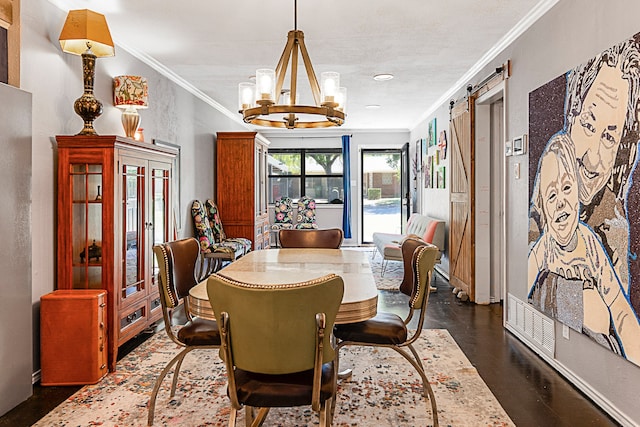 dining area with a notable chandelier, crown molding, and a barn door