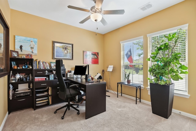 carpeted office space with ceiling fan and plenty of natural light