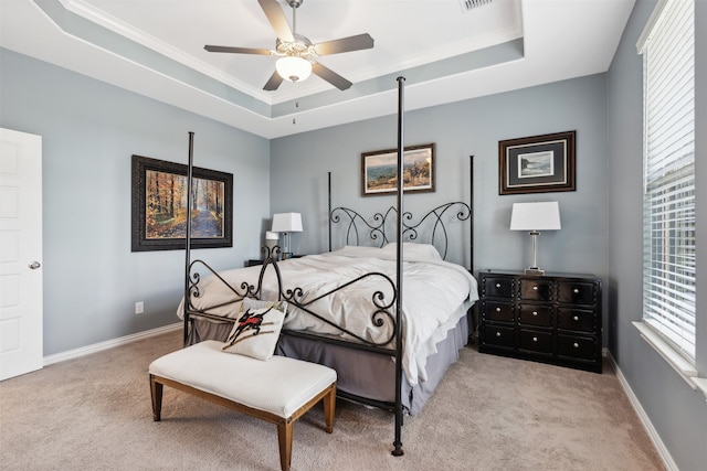 bedroom with light colored carpet, ceiling fan, and a raised ceiling