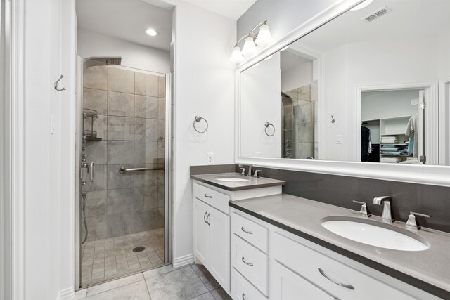 bathroom featuring tile patterned flooring, vanity, and a shower with door