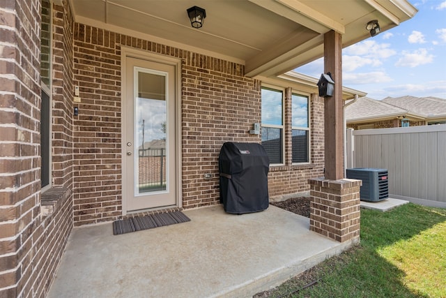 view of exterior entry with a patio area and central air condition unit