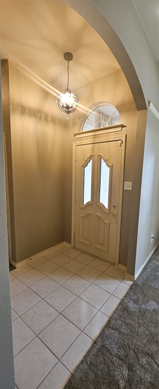 foyer with an inviting chandelier and light tile patterned floors