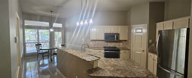 kitchen with dark tile patterned flooring, backsplash, appliances with stainless steel finishes, decorative light fixtures, and light stone countertops