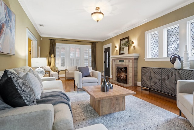 living room featuring a fireplace, light hardwood / wood-style floors, and crown molding